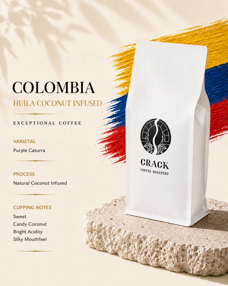 A white bag of Crack Coffee Roastery Colombia Huila Coconut Infused coffee stands on a textured stone slab. The background is a warm beige with stylized brushstrokes in the colors of the Colombian flag and text detailing the coffee's varietal, processing, and cupping notes.